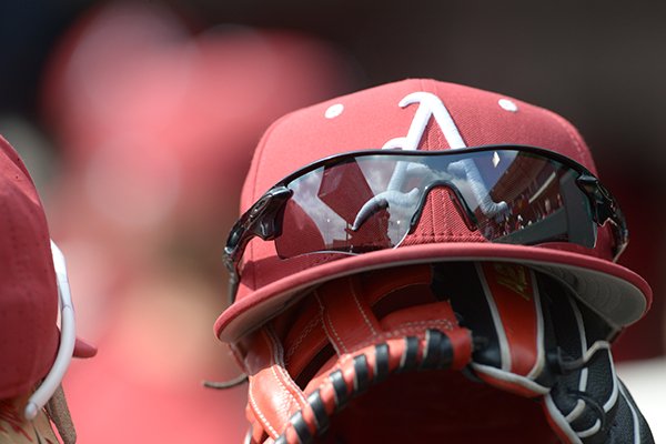 An Arkansas baseball hat sits atop a glove during a game between the Razorbacks and Kent State on Sunday, March 11, 2018, in Fayetteville. 