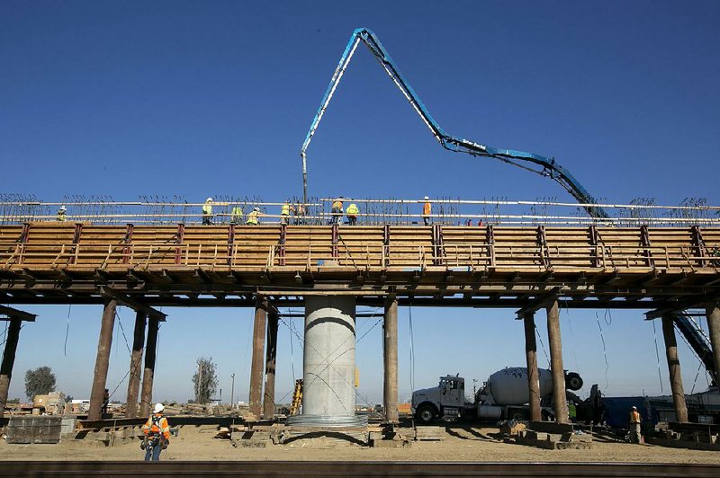Workers pour concrete onto an elevated section of the high-speed rail line that will cross the San Joaquin River near Fresno, Calif., in this December photo.