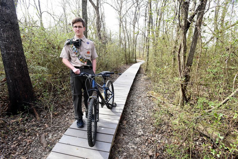 NWA Democrat-Gazette/FLIP PUTTHOFF Mason Walker shows a platform that's part of a mountain bike trail at Rogers New Tech High School he built for his Eagle Scout project. Several scouts, friends, parents and others helped with the work.