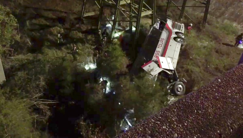 This photo provided by Jesus Tejada shows first responders searching around a bus that plunged into a ravine, Tuesday, March 13, 2018 on Interstate 10, Loxley, Ala.  Several people were on board, and all of them were brought to 10 hospitals in Alabama and Florida, either by helicopter or ambulance, said Baldwin County Sheriff Huey Hoss Mack.  (Jesus Tejada via AP)