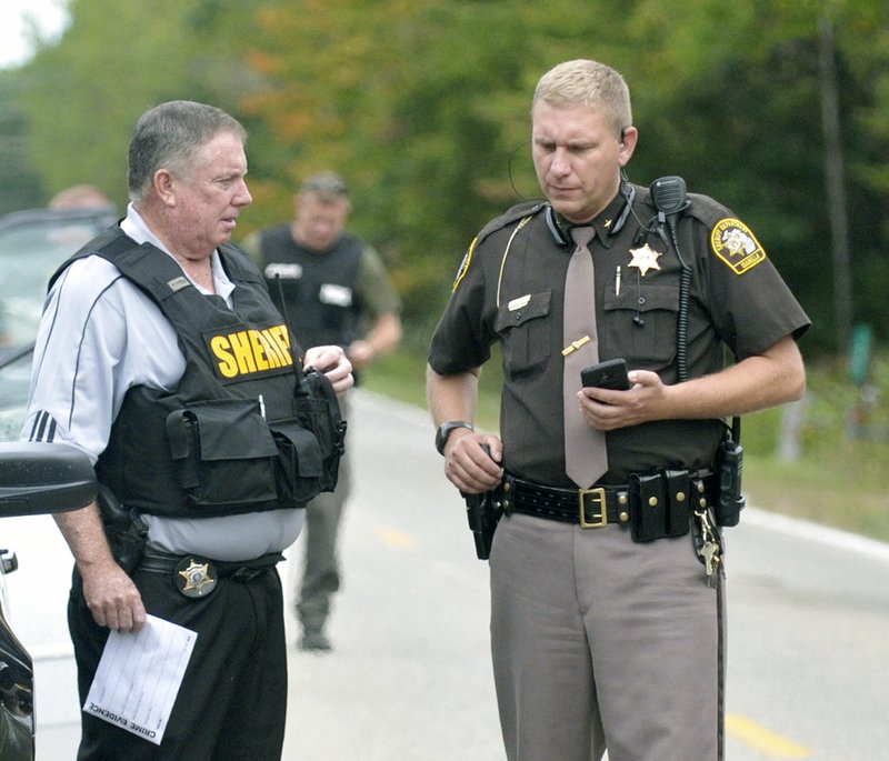 In this Sept. 27, 2017, photo, Isabella County Sheriff Michael Main, right, coordinates efforts in a police manhunt in rural Isabella County, Mich.