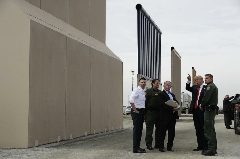 President Donald Trump gets a close look at border-wall prototypes Tuesday in San Diego. Trump later attended a high-dollar fundraiser in Los Angeles, where he was to stay overnight.