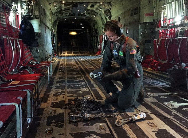 Airman 1st Class Devyn Freeze, a loadmaster, works with tie-downs Tuesday during a training flight on a C-130J out of Little Rock Air Force Base in Jacksonville. The base will participate in a weeklong “Fly In” that includes aircraft from around the world.