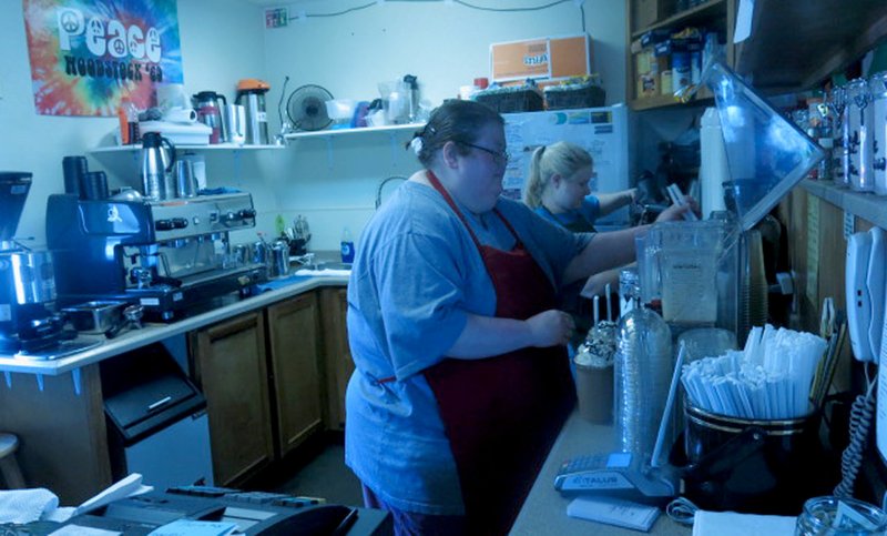 Westside Eagle Observer/SUSAN HOLLAND Michelle Strauser and Amber Haithcock were busy behind the counter preparing coffee drinks at Grumpy's Coffee Shop Saturday, March 3. Larry Jones, owner of Grumpy's, was celebrating his seventh year in business and the free drinks were one of the treats being offered to his customers.