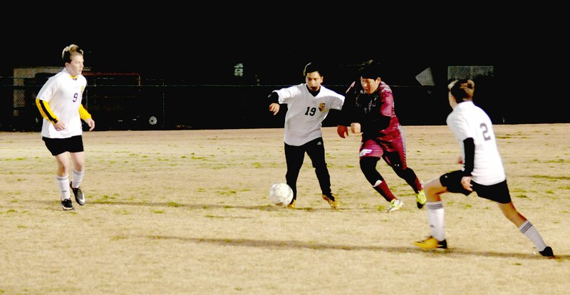 MARK HUMPHREY ENTERPRISE-LEADER Prairie Grove sophomore Blake Hickman battles a Lincoln player for control of the ball while Tiger teammates Cade Walker (left) and Luke Mitchell move in to help. Prairie Grove defeated Lincoln's junior varsity squad 2-1 in the school's first-ever high school boys soccer match on Tuesday, March 6.