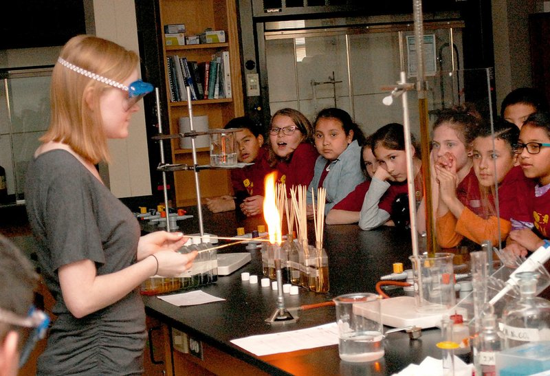 Janelle Jessen/Herald-Leader Fourth-graders gasped in amazement as Emily Logan, a JBU chemistry student, demonstrated how elements create different colored flames when they are burned.