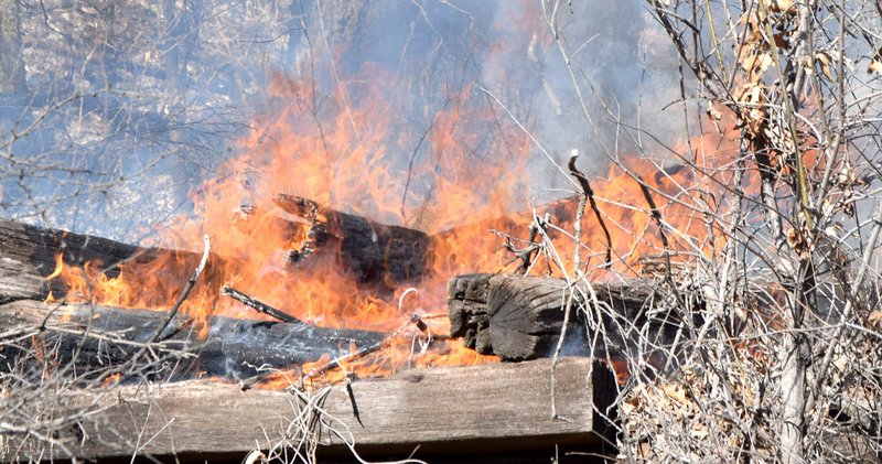 Westside Eagle Observer/MIKE ECKELS Old railroad ties catch fire during a controlled burn near the Kansas City Southern railroad right of way on the north side of Decatur March 8. Two piles of ties were the only thing destroyed in the fire.