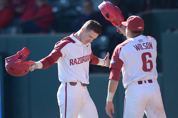 Arkansas third baseman Casey Martin is greeted by teammate Hunter Wilson after Martin hit a home run during a game against Texas on Wednesday, March 14, 2018, in Fayetteville. 