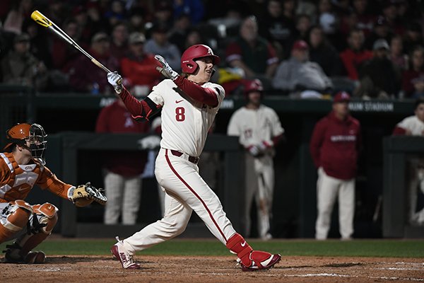 Arkansas outfielder Eric Cole hits a double during a game against Texas on Tuesday, March 13, 2018, in Fayetteville. 