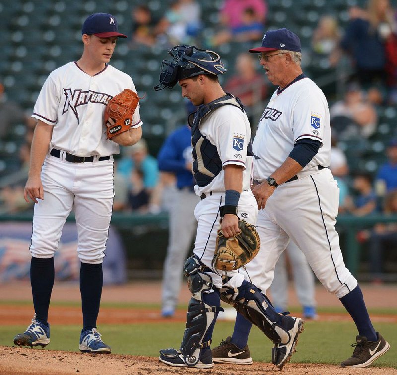 Northwest Arkansas Naturals pitcher Josh Staumont (left) receives a visit from catcher Nick Dini and pitching coach Steve Luebber during last season’s Texas League North Division Series in Springdale. Beginning this season, Class AA clubs will be allowed eight mound visits per game as part of Minor League Baseball’s plan to speed up its games. 