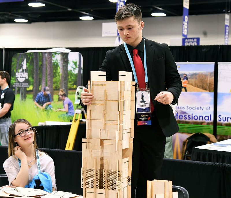 Caleb Keele, 15, of Russellville builds a structure from laser-cut pieces of wood Wednesday in an area sponsored by the University of Arkansas at the Environmental and Spatial Technology Conference in the Hot Springs Convention Center. 