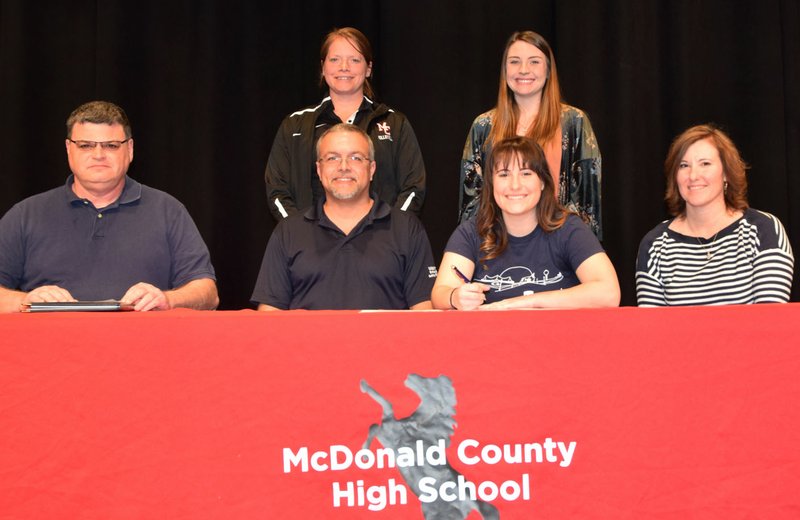 RICK PECK/SPECIAL TO MCDONALD COUNTY PRESS Hollie Garvin (seated, third from left) recently signed a letter of intent to play volleyball at Graceland University in Lamoni, Iowa. Pictured with her are Sean Matlock, Graceland University representative (front, left); Kevin Garvin; Hollie Garvin; Tonya Garvin; and MCHS coaches, Kacha Kuhn and Meghan Thompson.