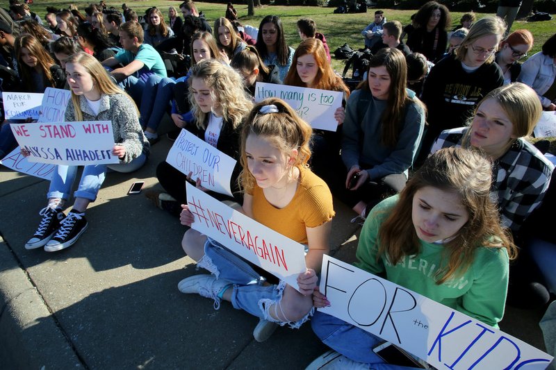 NWA Democrat-Gazette/DAVID GOTTSCHALK Bentonville High School students participate Wednesday in a 17-minute silent observance for the shooting victims of Marjory Stoneman Douglas High School in Parkland, Fla. About 400 students from the school participated in the silence and a series of chants and speeches as they lined Southeast J Street in Bentonville.