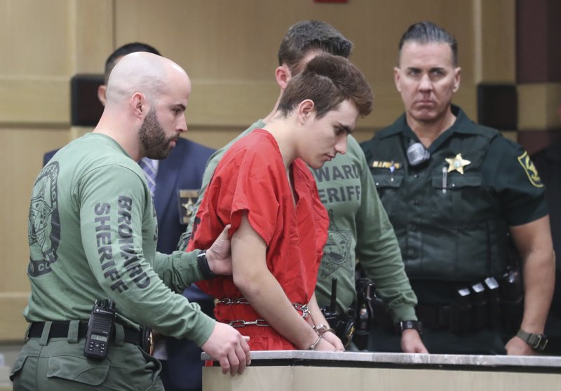Nikolas Cruz is lead into the courtroom before being arraigned at the Broward County Courthouse in Fort Lauderdale, Fla., on Wednesday, March 14, 2018. Cruz is accused of opening fire at Marjory Stoneman Douglas High School in Parkland, Fla., Feb. 14, killing 17 students and adults. 