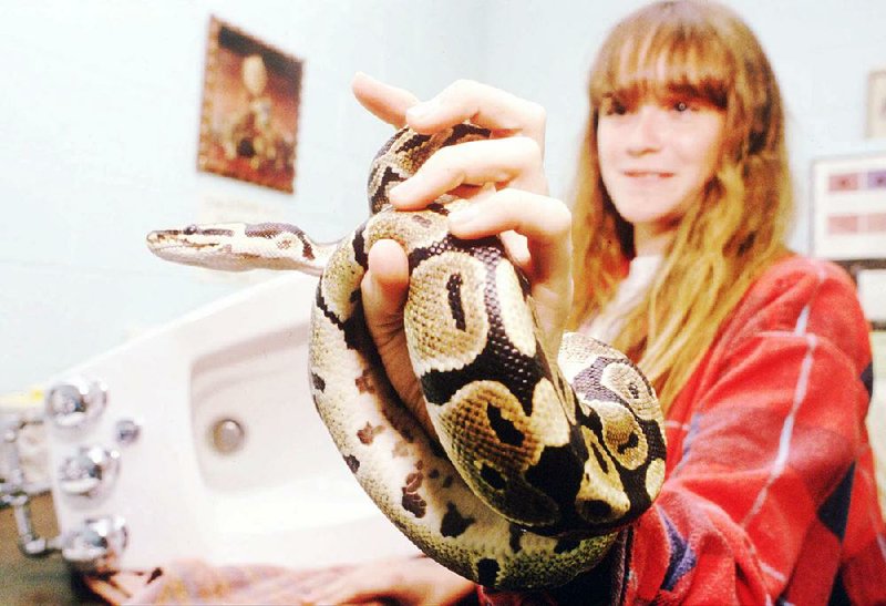 Dutch herpetologist Ymre Stiekema examines  an  Irish  barred  grass snake and the bidet in which it was hiding. The discovery of serpents in Ireland means St. Patrick’s days are numbered. Fayetteville-born Otus the Head Cat’s award-winning column of humorous fabrication appears every Saturday.

