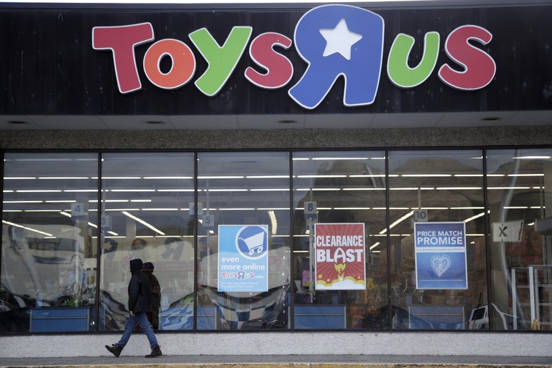 File- This Jan. 24, 2018, file photo shows a person walking near the entrance to a Toys R Us store, in Wayne, N.J. Toys R Us's management has told its employees that it will sell or close all of its U.S. stores. The 70-year-old retailer is headed toward shuttering its U.S. operations, jeopardizing the jobs of some 30,000 employees while spelling the end for a chain known to generations for its sprawling stores and Geoffrey the giraffe mascot. The closing of the company's 740 U.S. stores will finalize the downfall of the chain and force toy makers and landlords to scramble for alternatives. (AP Photo/Julio Cortez, File)