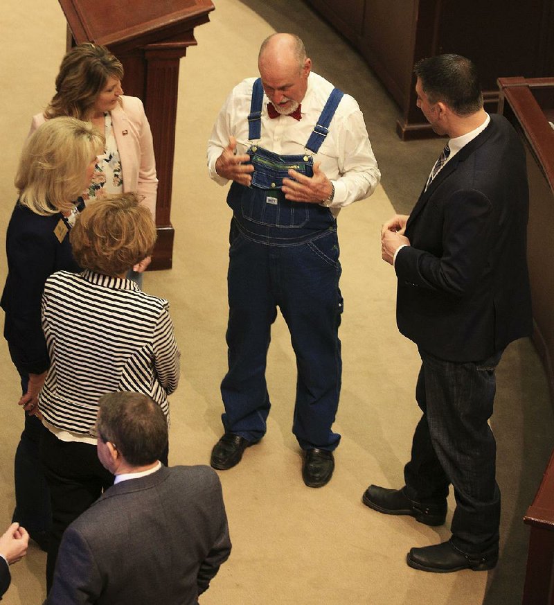 Rep. Mark McElroy (center), D-Tillar, talks with his colleagues Thursday before the House convenes on the final day of the special session. McElroy and other House members were allowed to wear denim for a $20 donation as part of the Do Pass for Denim fundraiser.
