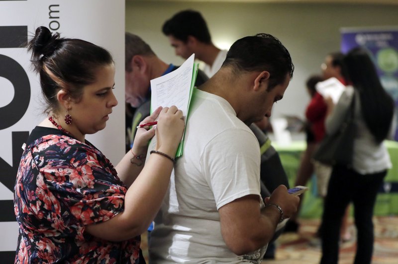 In this Jan. 30, 2018 photo, Loredana Gonzalez, of Doral, Fla., fills out a job application at a JobNewsUSA job fair in Miami Lakes, Fla. On Friday, March 9, 2018, the Labor Department reports on job openings and labor turnover for January. (AP Photo/Lynne Sladky)