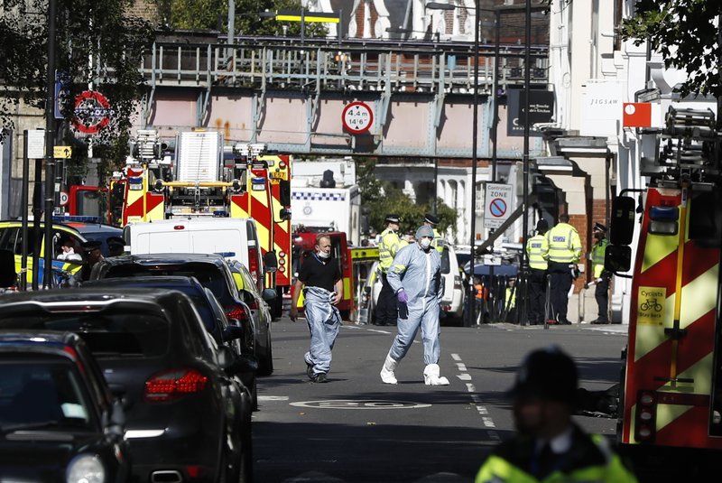 FILE - In this Friday, Sept. 15, 2017 file photo, police forensic officers walk within a cordon near where an incident happened, that police say they are investigating as a terrorist attack, at Parsons Green subway station in London. A jury has convicted an Iraqi teenager of attempted murder for planting a bomb on a London subway train. Ahmed Hassan, who is 18, showed no emotion as he was found guilty on Friday, March 16, 2018 at London's Central Criminal Court. He will be sentenced later. (AP Photo/Kirsty Wigglesworth, File)