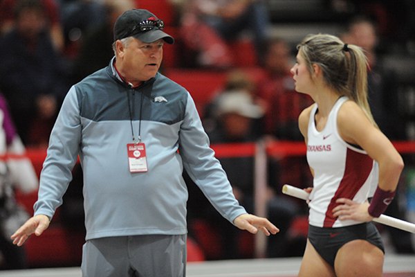 Arkansas assistant coach Bryan Compton speaks with Victoria Weeks as Weeks competes in the pole vault Friday, Jan. 15, 2016, during the Arkansas Invitational at the Randal Tyson Track Center. 