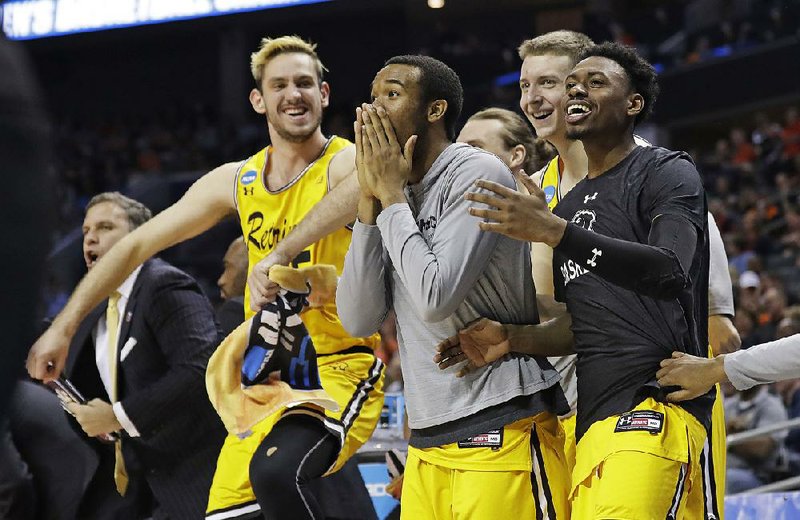 Maryland-Baltimore County players celebrate on the bench during No. 16-seeded Retrievers’ victory over top-seeded Virginia in the first round of the NCAA Tournament on Friday night in Charlotte, N.C. It marked the first victory by a 16 seed since the tournament switched from a 48-team bracket in 1985.
