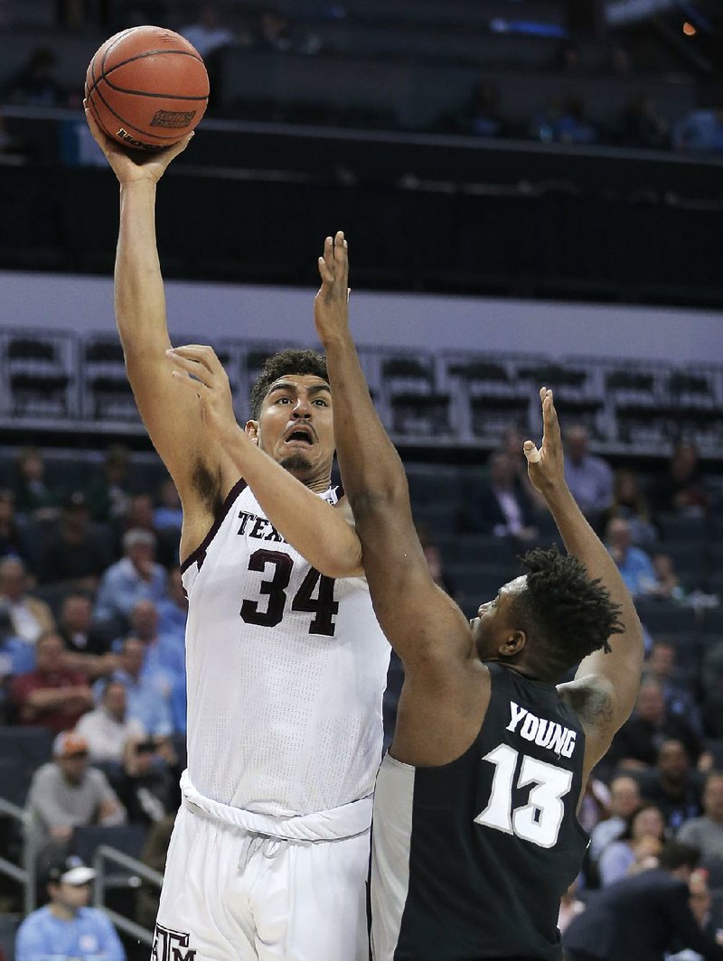 Texas A&M's Tyler Davis (34) shoots over Providence's Kalif Young (13) during the first half of a first-round game in the NCAA men's college basketball tournament in Charlotte, N.C., Friday, March 16, 2018. 