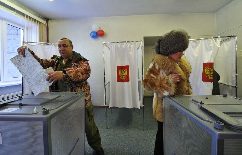 Russians at a polling station in the town of Yelizovo cast their ballots today in the country’s presidential election.