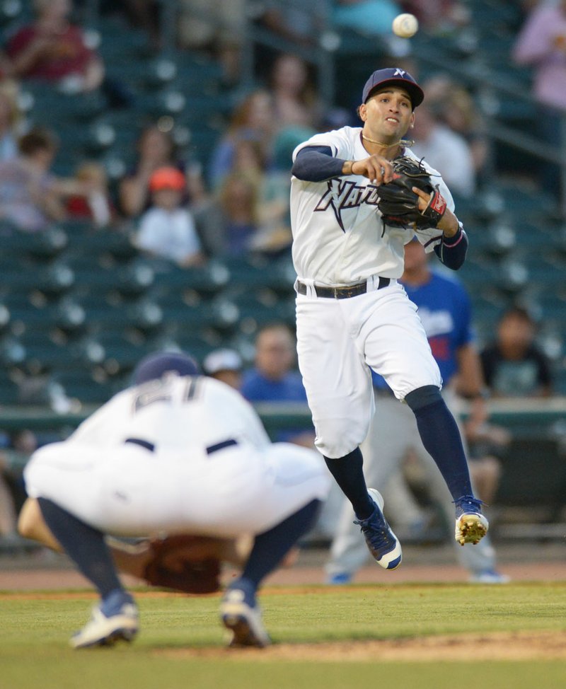 File photo/NWA Democrat-Gazette/ANDY SHUPE Northwest Arkansas Naturals third baseman Jack Lopez (right) makes the throw to first before leaping over starting pitcher Josh Staumont against Tulsa Drillers during the second inning of the Texas League North Division Series at Arvest Ballpark in Springdale.