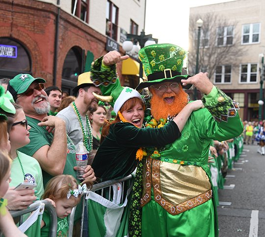 The Sentinel-Record/Grace Brown READY TO PADDY: Tracy Barrett hugs the "World's Tallest Leprechaun," Monte Everhart, on Saturday before the start of the First Ever 15th Annual World's Shortest St. Patrick's Day Parade.