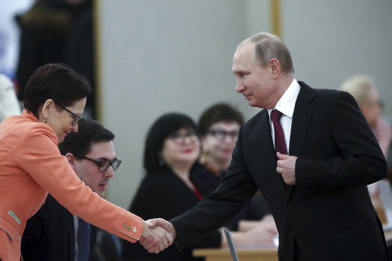 Russian President and Presidential candidate Vladimir Putin shakes hands with a member of the election commission as he arrives to vote at a polling station during Russia's presidential election in Moscow, Russia, Sunday, March 18, 2018. Putin's victory in Russia's presidential election Sunday isn't in doubt. The only real question is whether voters will turn out in big enough numbers to hand him a convincing mandate for his fourth term — and many Russian workers are facing intense pressure to do so. (Sergei Chirikov/Pool Photo via AP)

