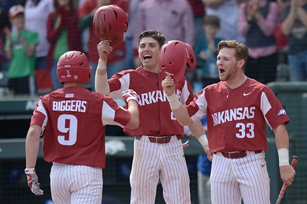 Arkansas shortstop Jax Biggers (9) is congratulated at the plate by second baseman Carson Shaddy (center) and Grant Koch (33) after hitting a 3-run home run against Kentucky Saturday, March 17, 2018, during the fifth inning at Baum Stadium in Fayetteville.