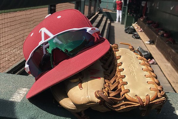 An Arkansas baseball hat and glove sit in the dugout prior to a game between the Razorbacks and Kentucky on Saturday, March 17, 2018, in Fayetteville. 