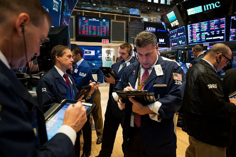 Traders work Monday on the floor of the New York Stock Exchange, where 29 of the 30 stocks in the Dow Jones industrial average posted losses for the day.