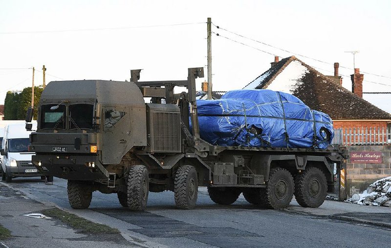 A vehicle wrapped in blue tarpaulin is removed Monday in Durrington, England, on the back of an Army lorry, as the investigation into the suspected nerve-agent attack on Russian double agent Sergei Skripal and his daughter continues.