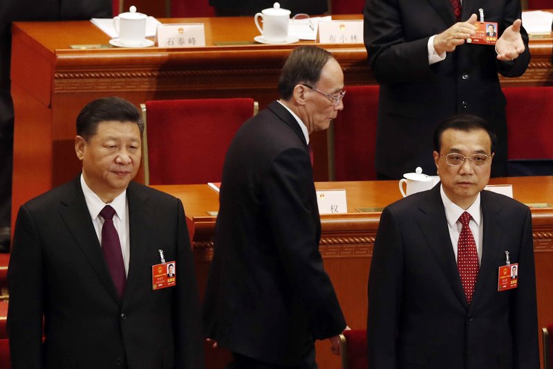 Chinese President Xi Jinping, left, and Premier Li Keqiang, right, stand as Vice President Wang Qishan arrives at the closing session of the annual National People's Congress in Beijing's Great Hall of the People in Beijing, China, Tuesday, March 20, 2018. (AP Photo/Ng Han Guan)
