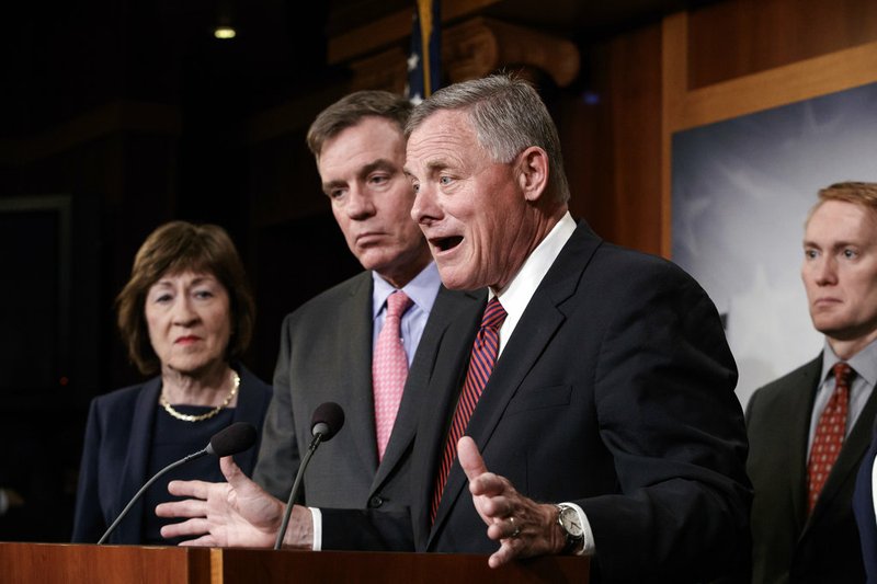 Members of the Senate Intelligence Committee, including Chairman Sen. Richard Burr, R-N.C., left, Vice Chair Sen. Mark Warner, D-Va., Sen. Susan Collins, R-Maine, Sen. James Lankford, R-Okla., and Sen. Martin Heinrich, D-N.M., react as the group declines to answer a question about President Donald Trump on Tuesday, March 20, 2018, on Capitol Hill in Washington. 