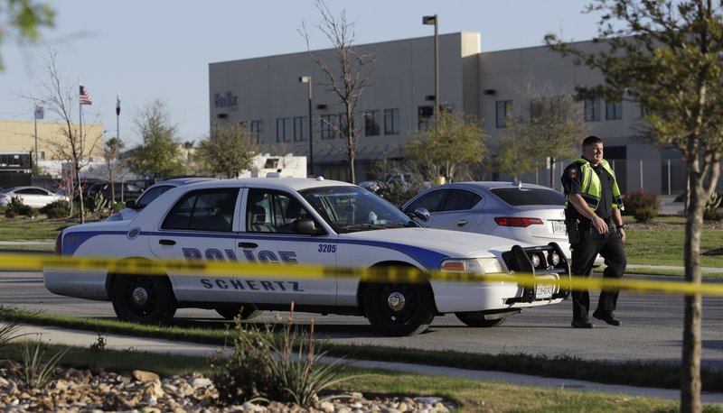A police officer stops a vehicle at a check point in front of a FedEx distribution center where a package exploded, Tuesday in Schertz, Texas. Authorities believe the package bomb is linked to the recent string of Austin bombings.