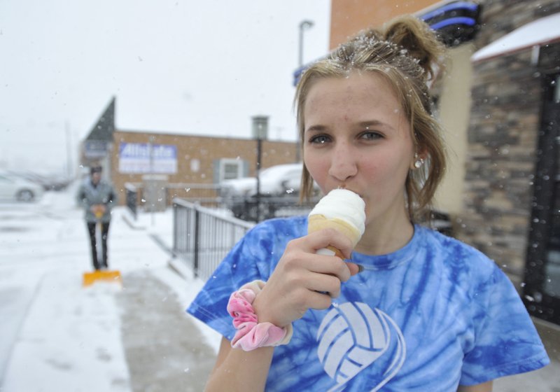 Westmont High School student enjoys a free ice cream cone from the Westmont Dairy Queen location in Johnstown, Pa. as snow falls today, the first day of spring. The Dairy Queen Corporation was giving out one free cone per customer to celebrate the first day of spring. 
