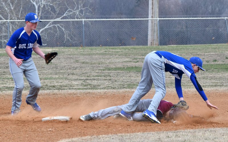 Westside Eagle Observer/MIKE ECKELS After tagging the base, Paul Ehrhart, (Bulldog second baseman) is knocked over by a Leopards' runner in the third inning of the Decatur-Alpena conference baseball game at Edmiston Park in Decatur March 12.