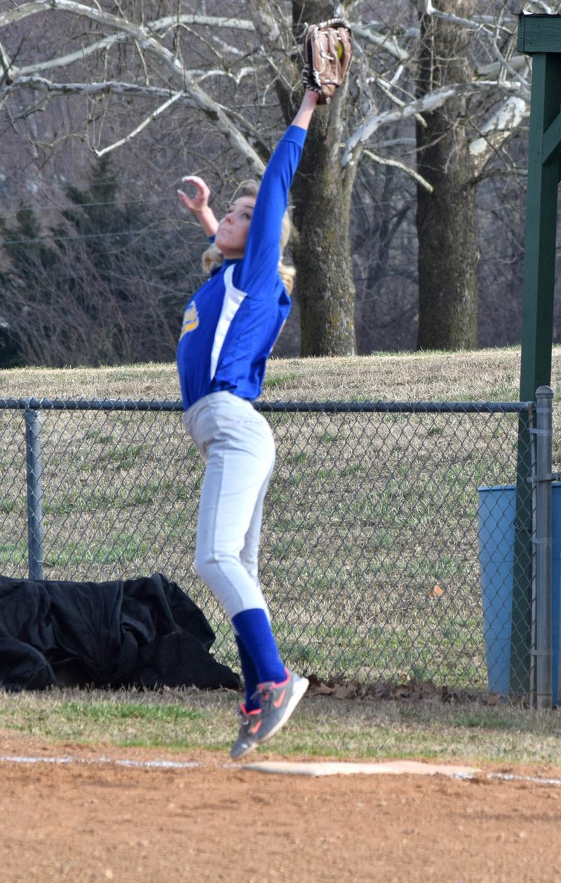 Westside Eagle Observer/MIKE ECKELS Talor Thompson reaches high for an overthrown ball during the second inning of the Decatur-Eureka Springs fast-pitch softball game at Edmiston Park in Decatur March 12. Thompson's efforts paid off as she was able to pull down the ball in time to get the runner out at first base.