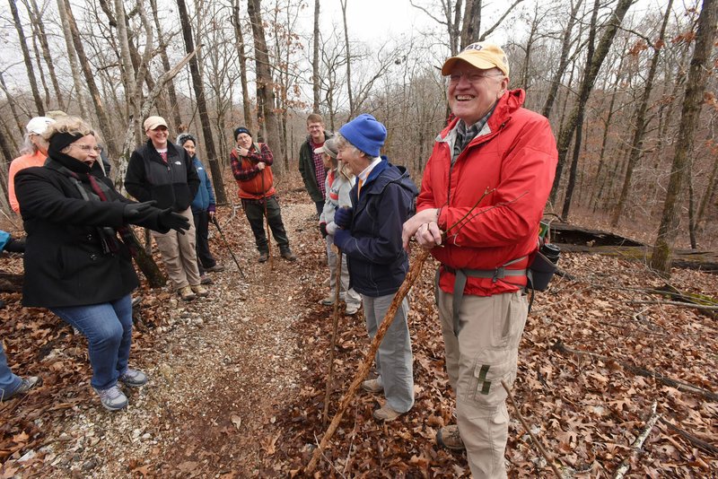 NWA Democrat-Gazette/FLIP PUTTHOFF
Cris Jones (from right) and Eleanor Jones show hikers how to identify trees by their bark and branches. The group identified tall hardwoods, such as oaks and hickories, and shorter understory trees like red buds and dogwoods. The tree identification hike on Feb. 17 2018 was held on two miles of the Back 40 Trail System in Bella Vista.