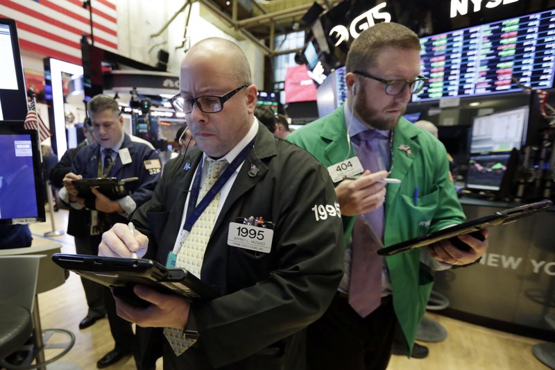 Traders Jeffrey Vazquez, center, and Ryan Falvey, right, work on the floor of the New York Stock Exchange, Tuesday, March 20, 2018. Banks and energy stocks are leading early gains for U.S. indexes. (AP Photo/Richard Drew)