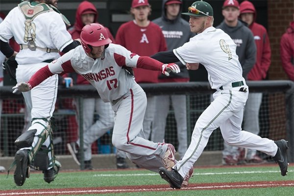 Arkansas designated hitter Luke Bonfield is tagged out by Charlotte infielder Tommy Bullock during a game Wednesday, March 21, 2018, at Hayes Stadium in Charlotte, N.C.