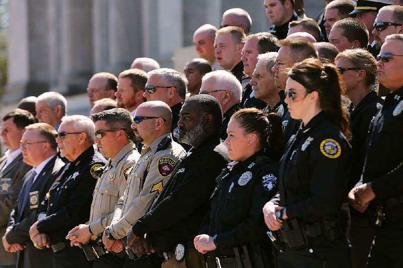 Law enforcement officers from across Arkansas stand on the Capitol steps Wednesday as officials announce an opioids lawsuit that was filed in Crittenden County.  