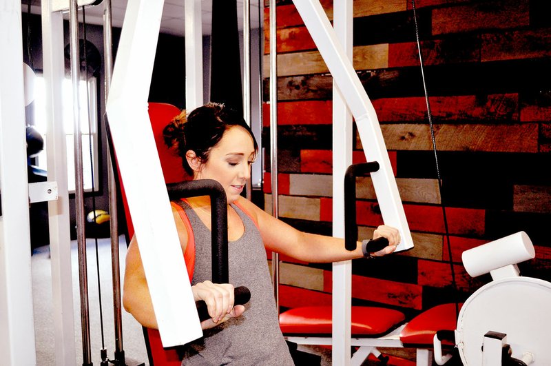 RACHEL DICKERSON/MCDONALD COUNTY PRESS Hailee Allison works out on a cable machine at Alpha Company Gym in Anderson.