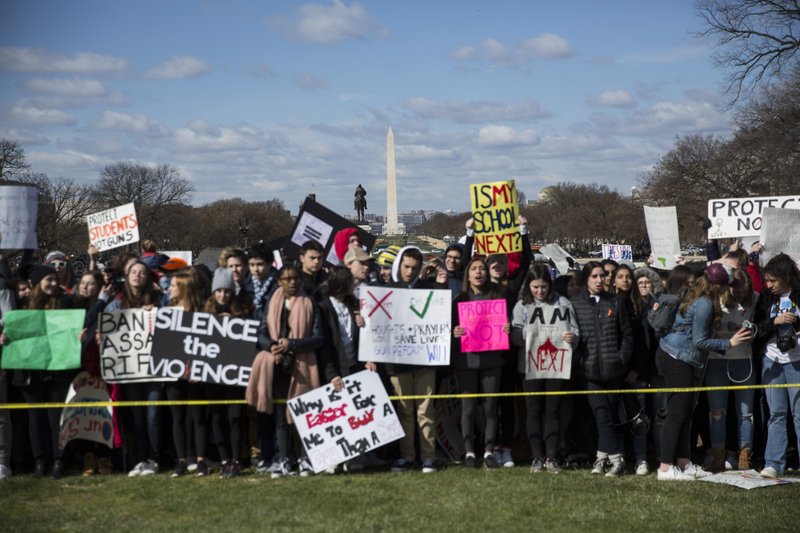 With the Washington Monument as a backdrop, students hold signs during the ENOUGH: National School Walkout rally in Washington, D.C., on March 14, 2018. Students nationwide left classrooms to protest gun violence, the gun industry, and what many of them consider to be America's dangerously lax gun laws.