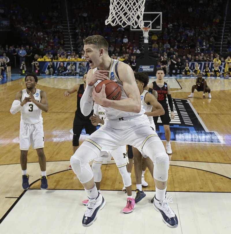 Michigan forward Moritz Wagner (13) grabs a rebound during the second half of the team's NCAA men's college basketball tournament second-round game against Houston on Saturday, March 17, 2018, in Wichita, Kan. Michigan won 64-63. (AP Photo/Charlie Riedel)