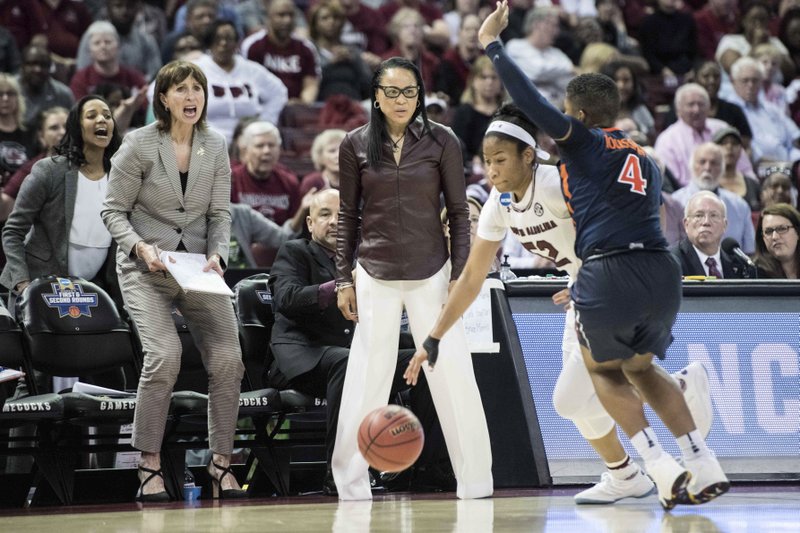 South Carolina head coach Dawn Staley, center, watches Tyasha Harris (52) dribble the ball against Virginia guard Dominique Toussaint (4) during the first half of a second-round game of the NCAA women's college basketball tournament, Sunday, March 18, 2018, in Columbia, S.C. South Carolina defeated Virginia 66-56. (AP Photo/Sean Rayford)