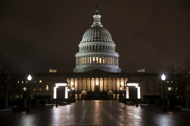 The Capitol is seen before dawn Wednesday after a night of negotiating on the government spending bill in Washington, March 21, 2018. 