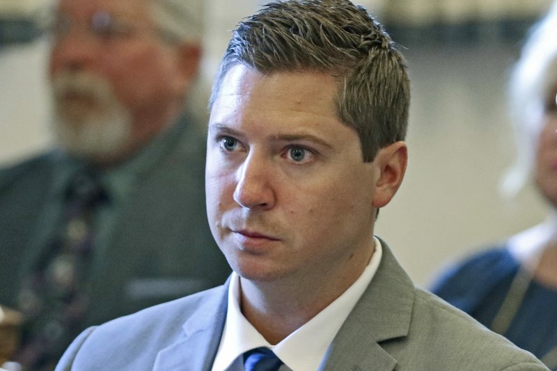 In this June 8, 2017, file pool photo, Ray Tensing listens to a prosecutor's opening statement during the former University of Cincinnati police officer's retrial at the Hamilton County Courthouse in Cincinnati. The University of Cincinnati has agreed to pay some $344,000 in back wages and legal fees to a white police officer the school fired after he fatally shot a black unarmed motorist. The school announced the settlement Thursday, March 22, 2018, of a union grievance brought on behalf of Tensing for his 2015 firing following his indictment on murder charges. The charges were dropped last year after two juries deadlocked. 